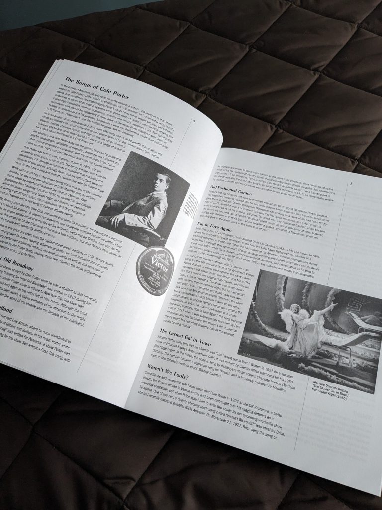 A double spread of pages from the Cole Porter Song Collection, with information about Cole Porter framing a picture of him on the left page and an image of Marlene Dietrich on the right.